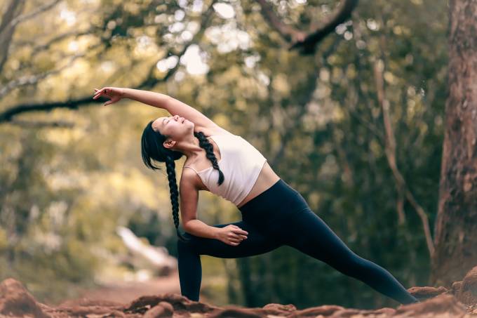 Una mujer hace yoga en el bosque. 