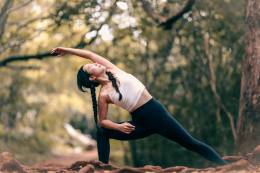 Woman does yoga in the woods. 