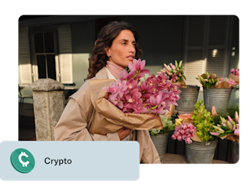 Une femme tient un bouquet d'orchidées roses devant un stand de fleurs, avec une superposition montrant une icône de crypto et le mot 'Crypto'.