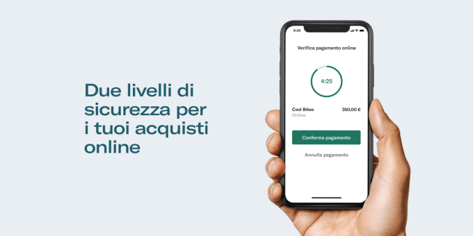 Mano che tiene smartphone con schermata di conferma del pagamento PSD2 visualizzata.