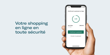 Main tenant le smartphone avec écran de confirmation de paiement PSD2 affiché.