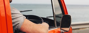 Man driving a car, elbow out of the window.