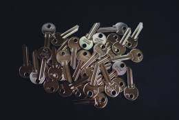 A pile of metal keys with dark background.