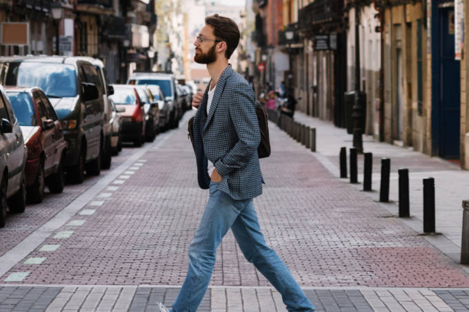 L'uomo vestito di uno stile casual e attraversando una strada a Madrid.