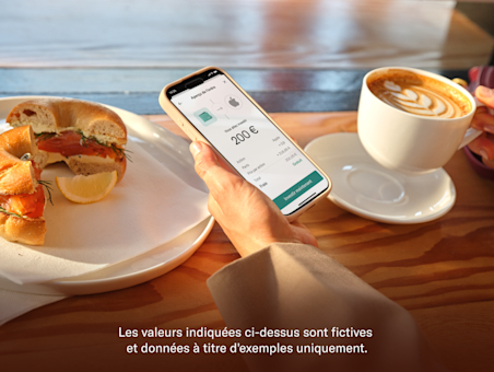 Une main tient un smartphone affichant l'écran de prévisualisation de commande d'investissement N26 à une table de café.