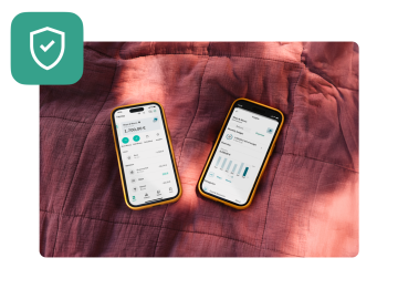 Two mobiles showing the N26 joint account accounts interface laying on a red duvet. 