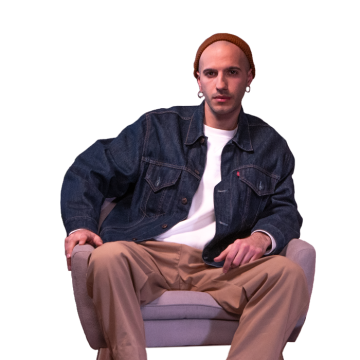 A young man wearing a beanie and sitting on an armchair.