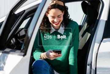 Logos N26 et Bolt avec l'image d'une femme assise sur une voiture et regardant son téléphone portable en arrière-plan.