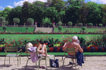 Ein älterer Mann und eine Frau sitzen in einem Park.