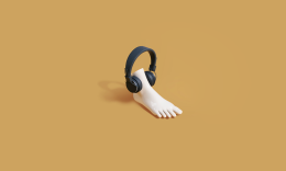A fake plastic feet wearing a black headphone speaker.