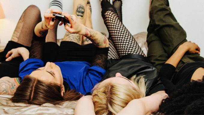 Students relaxing on a bed.