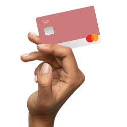 Eine Hand hält eine rhabarberfarbene N26-Karte.