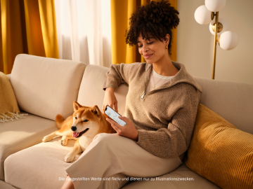 Die Frau saß auf einer Couch und schaute in ihre mobilen N26 Crypto-Funktionen.