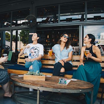 Chicas tomando una cerveza en una terraza.