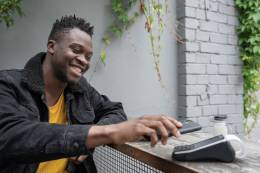 Young man paying at cafe bar with cash back app.