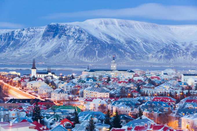 vista sulle chiese e la città di Reykjavik elevato con uno sfondo di montagne innevate.