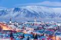 Blick über die Kirchen und Stadtbild von Reykjavik mit einer Kulisse von schneebedeckten Bergen.