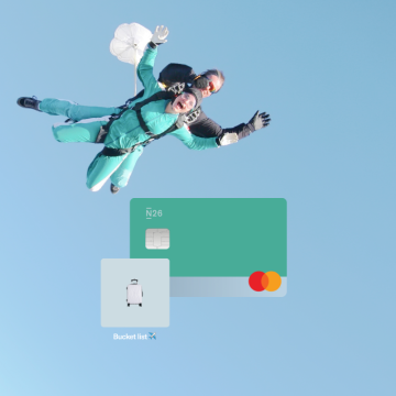 A woman in the company of her instructor doing skydiving and a N26 teal card with a space called bucket list.
