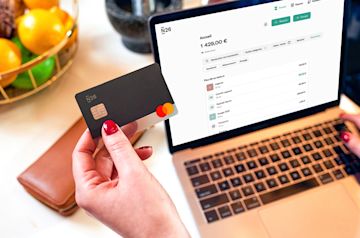Femme vérifiant son relevé bancaire et tenant une carte de débit N26.