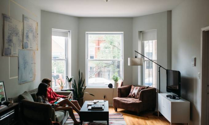 Man and woman sitting on couch in living room.