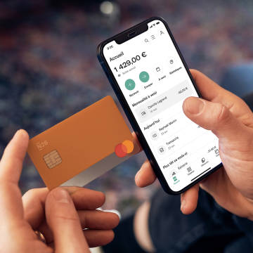 Image montrant une personne avec une carte de débit N26 et l'application N26 affichant le flux de compte avec la liste des transactions.