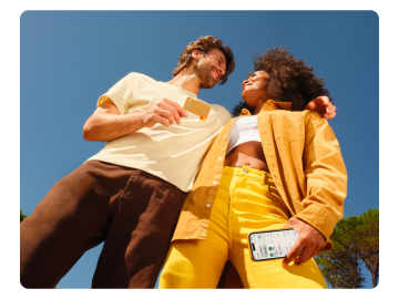 Un homme et une femme sont proches l'un de l'autre. L'homme tient une carte de couleur sable N26, tandis que la femme a l'application N26 ouverte sur son téléphone portable.