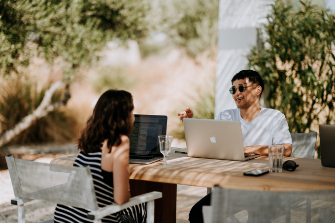 Due persone che lavorano su laptop all'esterno.