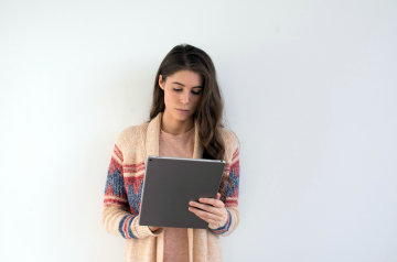 A woman reading on a tablet. 