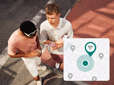 Two men stand on a city street, overlaid with a map icon marking an ATM location.