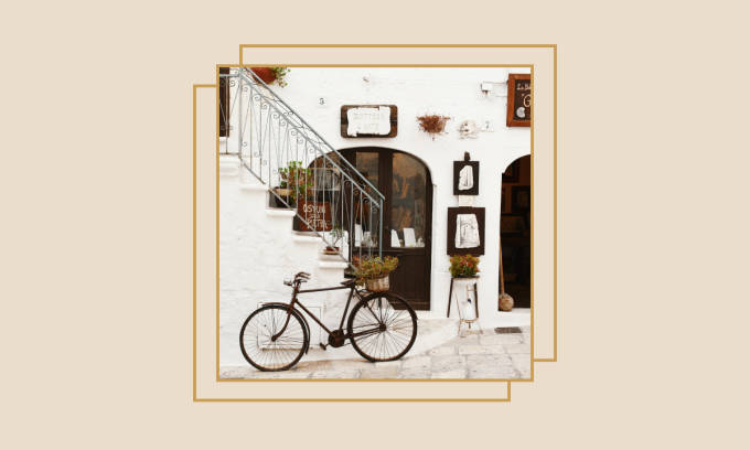Bicycle leaning in front of a shop in an Italian village.