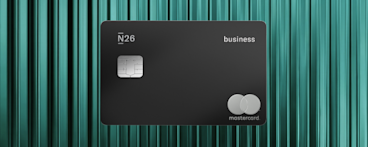 Une carte N26 Metal noir mat avec une puce argentée et un logo Mastercard minimaliste sur un fond texturé bleu sarcelle.
