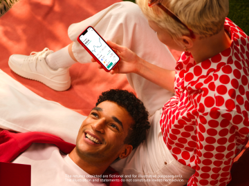 Woman sitting watching Crypto on the N26 app with a man lying next to her.