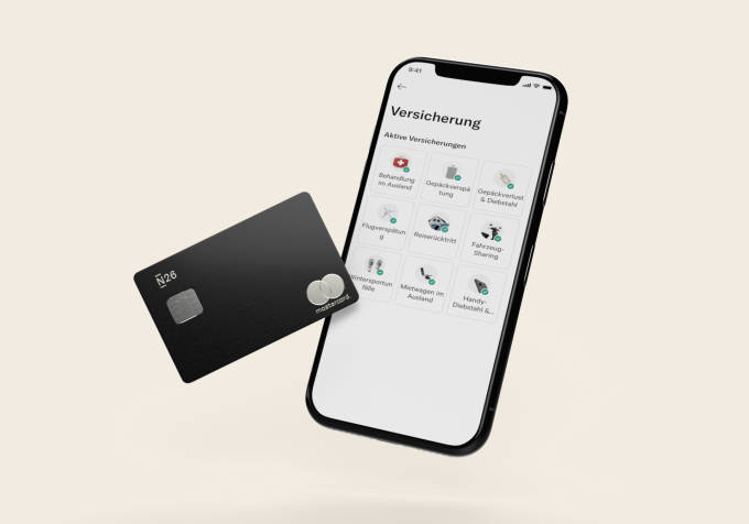 Bild der N26 Metal Black Card und der N26 App mit dem Abschnitt zur Handyversicherung.