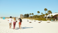 Trois personnes marchant sur une plage.