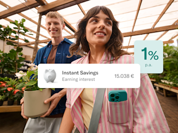 A couple walks through a greenhouse with an overlaid card showing an Instant Savings balance and an interest rate of 1% p.a.
