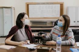 Two Erasmus students in a classroom wearing face masks.