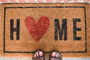a house mat with the word "Home" and a red heart instead od letter o.
