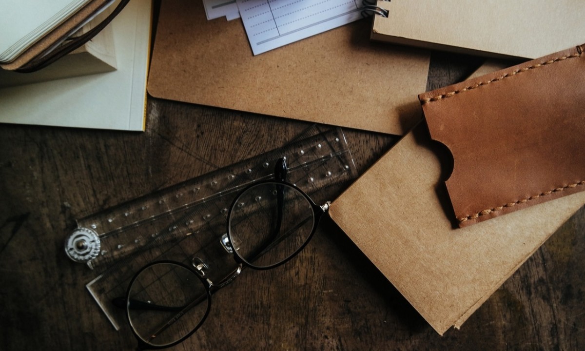 Des dossiers et des lunettes sur le bureau d'un auto-entrepreneur.