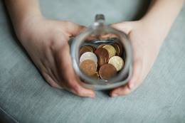 kid showing the coins placed in a glass jar.