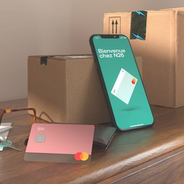 Image d'une carte rose N26 YOU et d'une APP N26 sur une table avec deux boîtes.