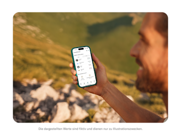 Ein wandernder Mann schaut auf sein Telefon, das den N26-Investmentbildschirm mit einer Liste beliebter Aktien anzeigt.