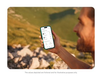 A man hiking looks at his phone displaying the N26 Investments screen with a list of popular stocks.