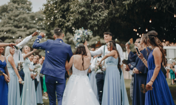 A bride and groom surrounded by wedding attendees.