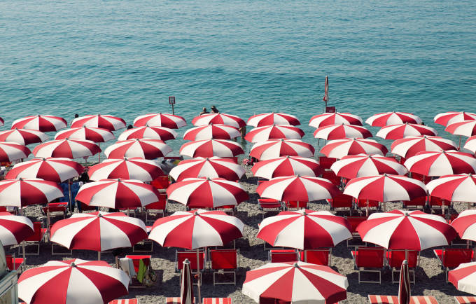Weiss und rot gestreifte Sonnenschirme am Strand.