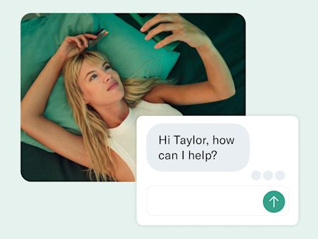 A woman lies on a teal-colored bed with a greeting message in the foreground.