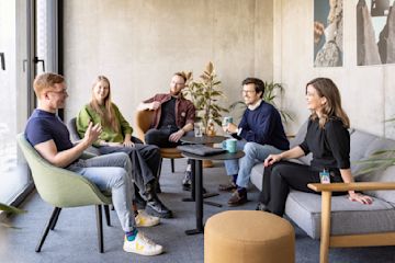 N26 Team, zwei Frauen beim Mittagessen im Büro mit Blume vorne.