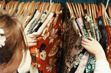 Una mujer comprando camisas.