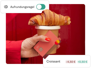 Eine Hand greift nach einer Tasse Kaffee, einem Croissant und einer N26-Rhabarber-Karte.