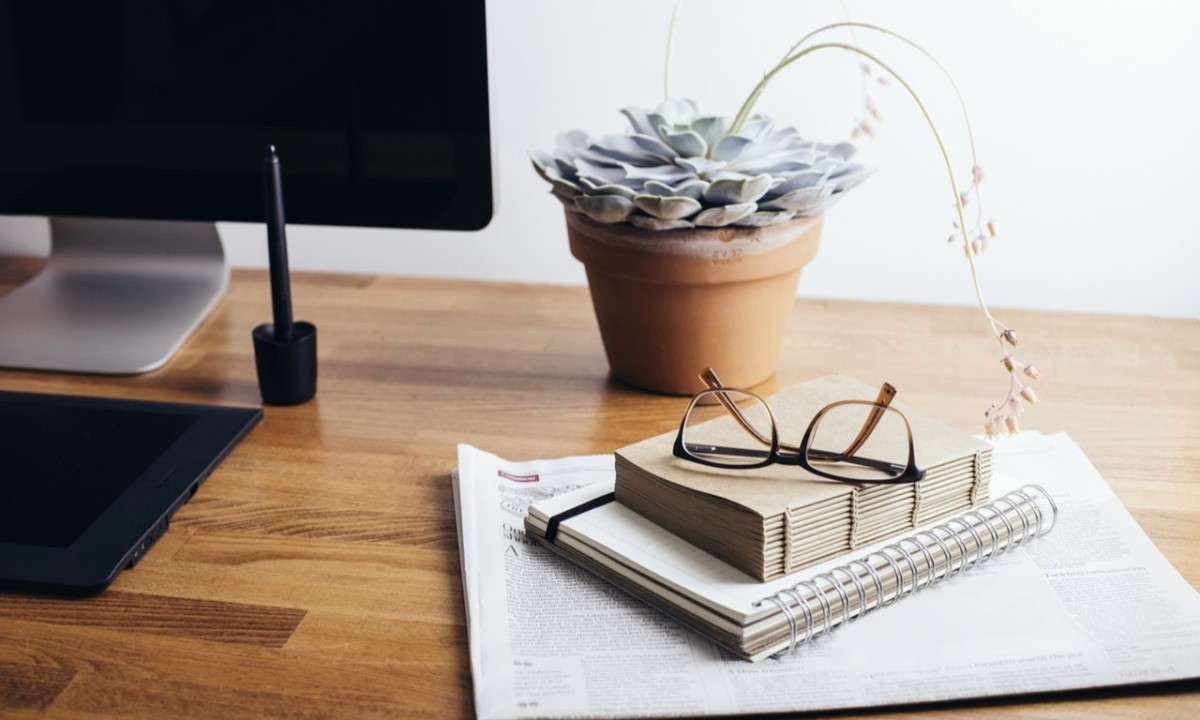 escritorio de un freelance con plantas y libros.