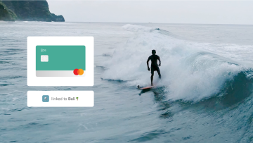 Person on a surfboard with an N26 card link to Bali space.